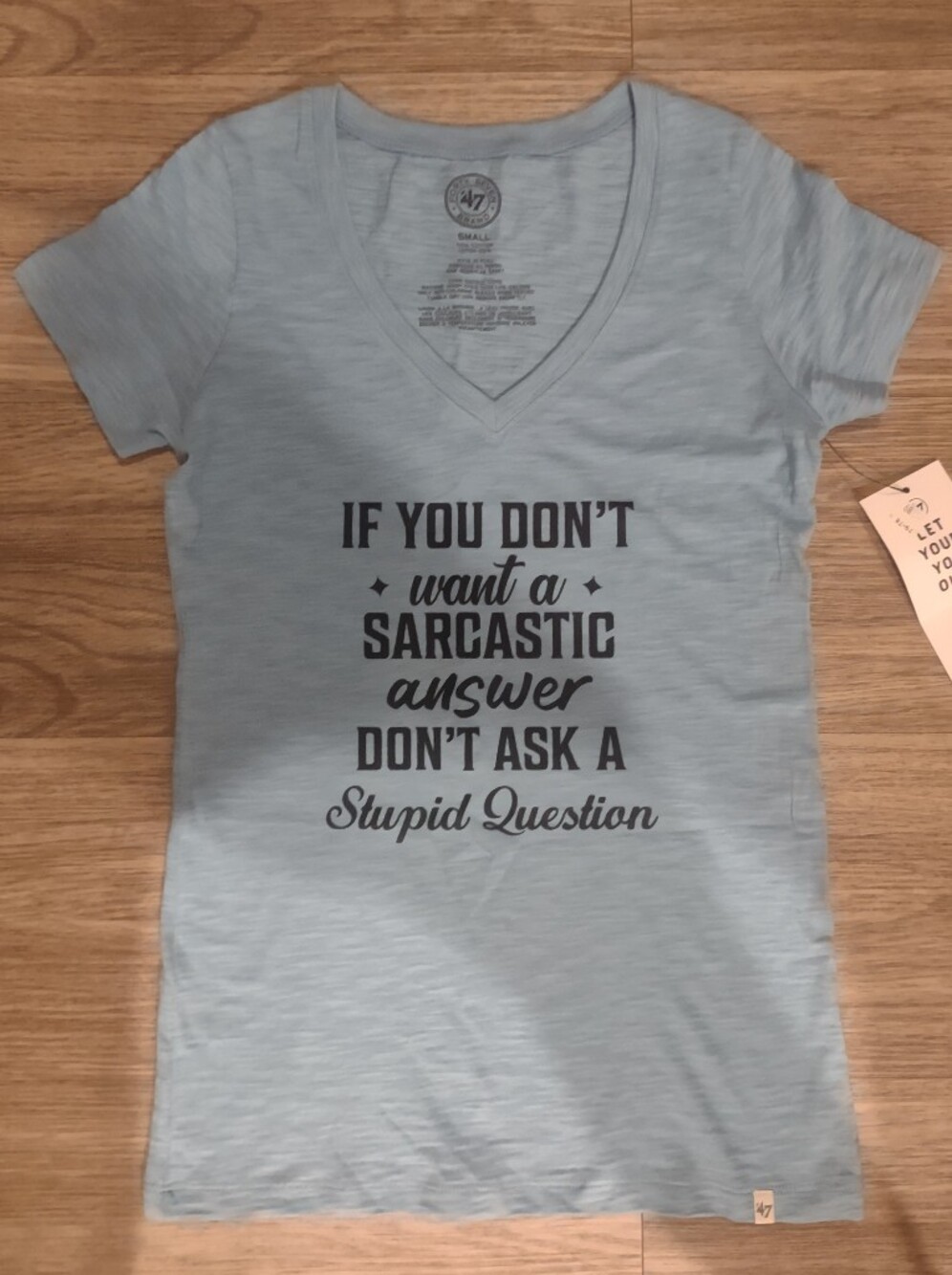 47 Light Blue V‑Neck Graphic Tee with Black Text